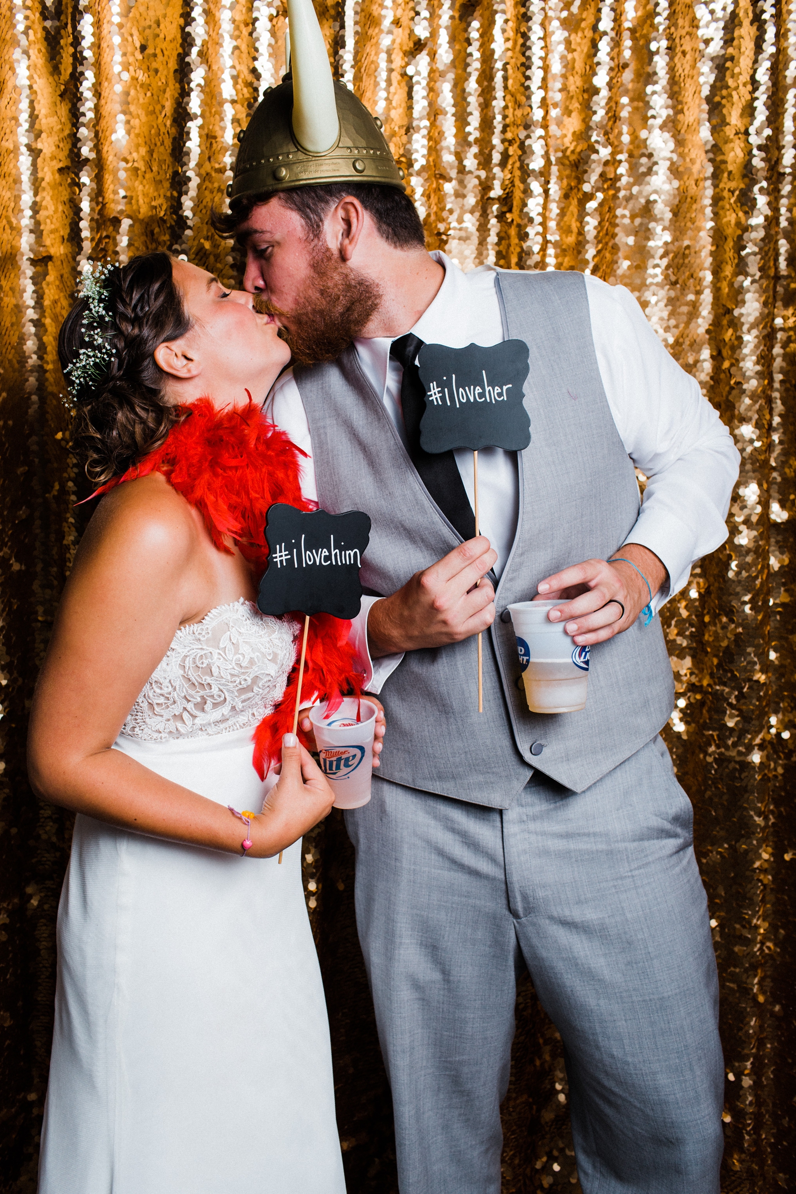 Bride and groom kissing in gold sequin photo booth at Little Piney Lodge in Hermann MO. 