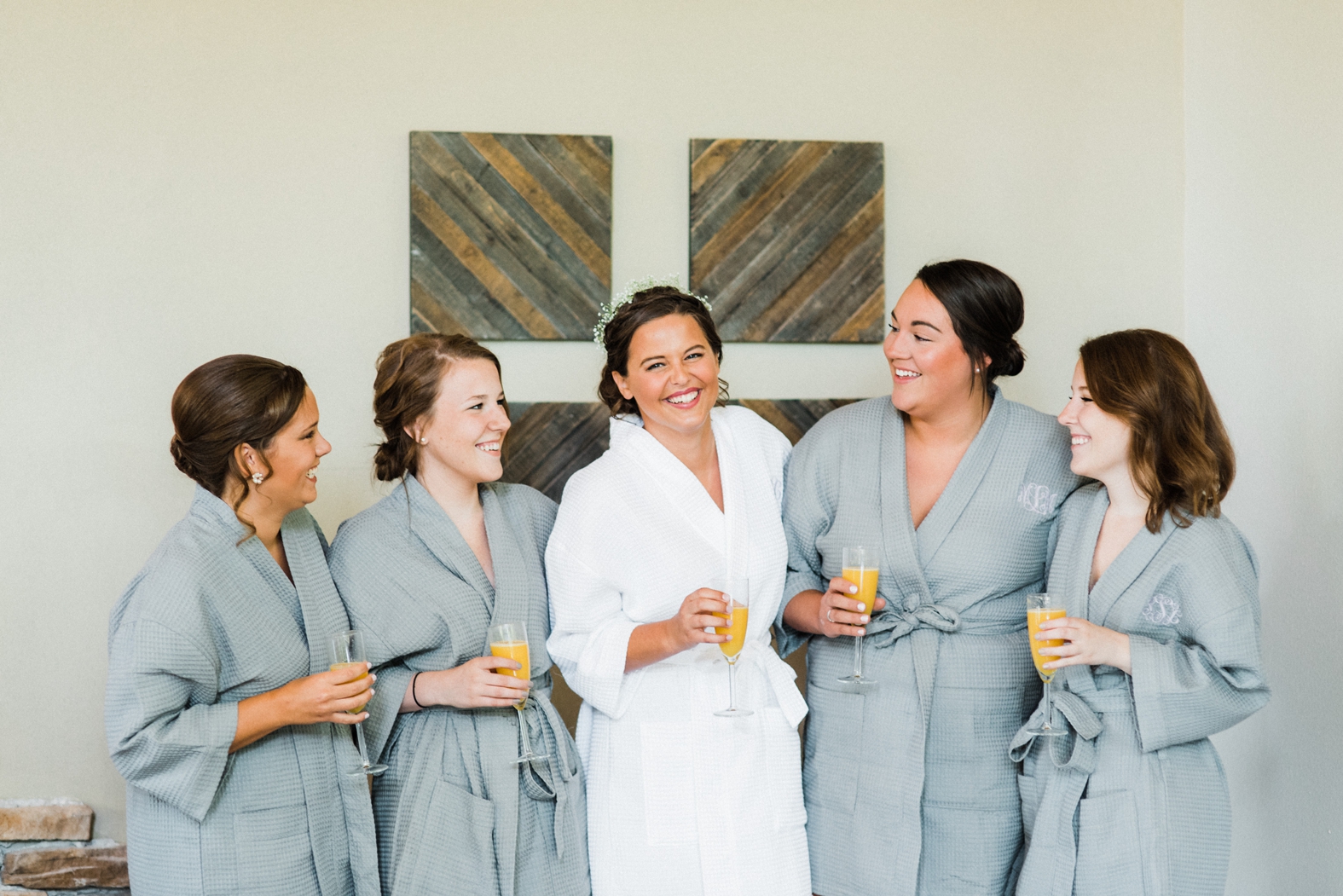 Bride and bridesmaids getting ready in monogrammed robes with mimosas; bridal party