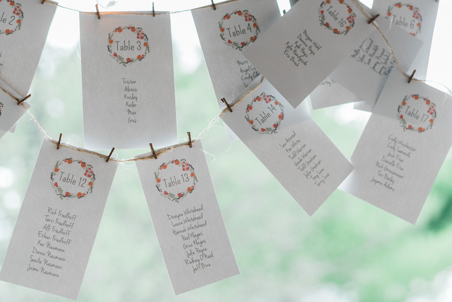 Wedding seating chart on cardstock hanging by twine.
