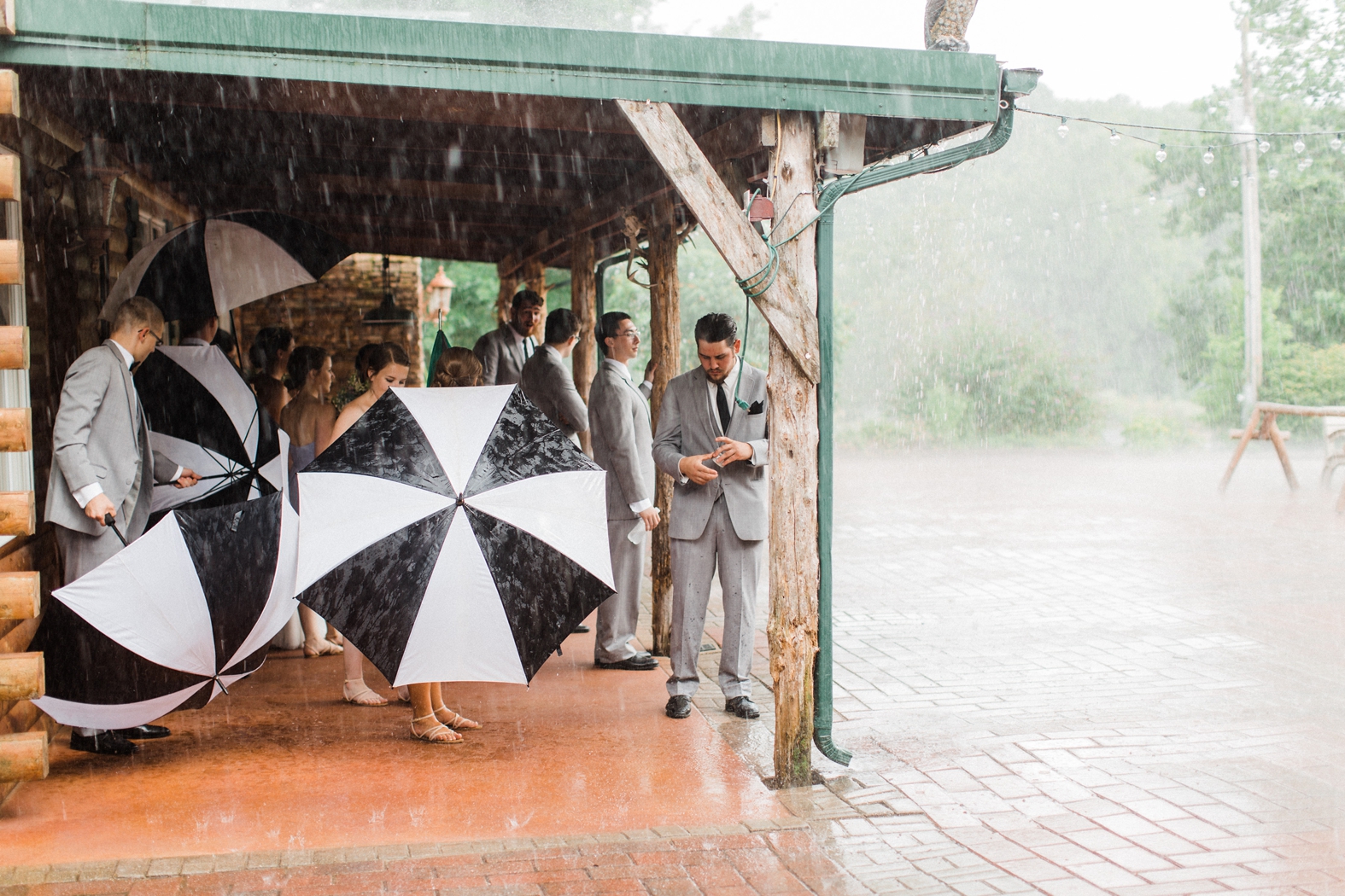 wedding party in rain with black and white umbrellas