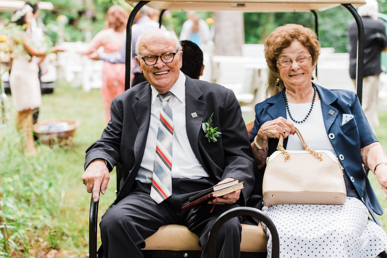 Wedding guests smiling on golf cart at Little Piney Lodge in Hermann, MO