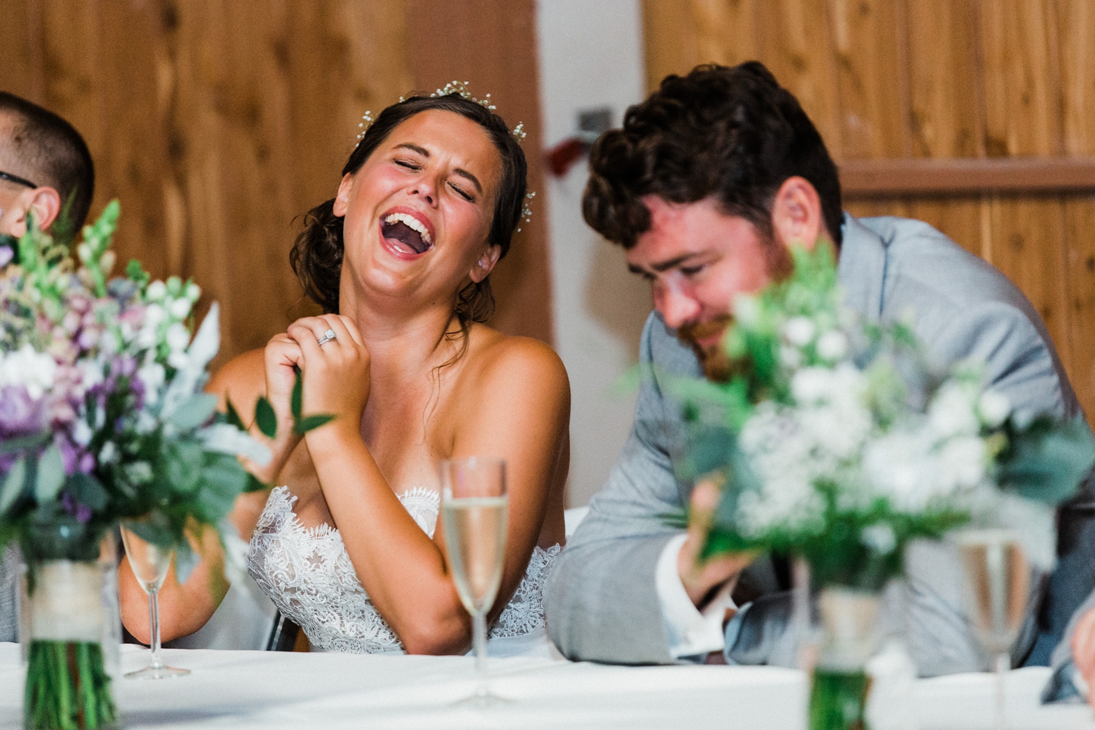 Bride and groom laughing at toasts in party barn at Little Piney Lodge in Hermann, MO