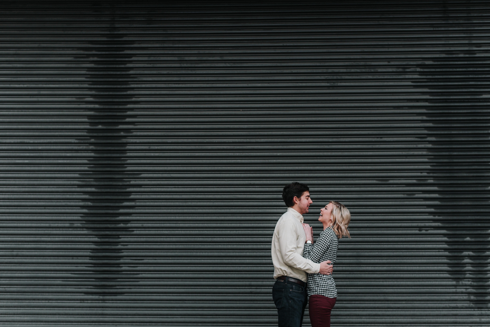 Engaged couple embraces and laughs during their downtown St. Louis winter engagement photo session at the Peabody Office Building.